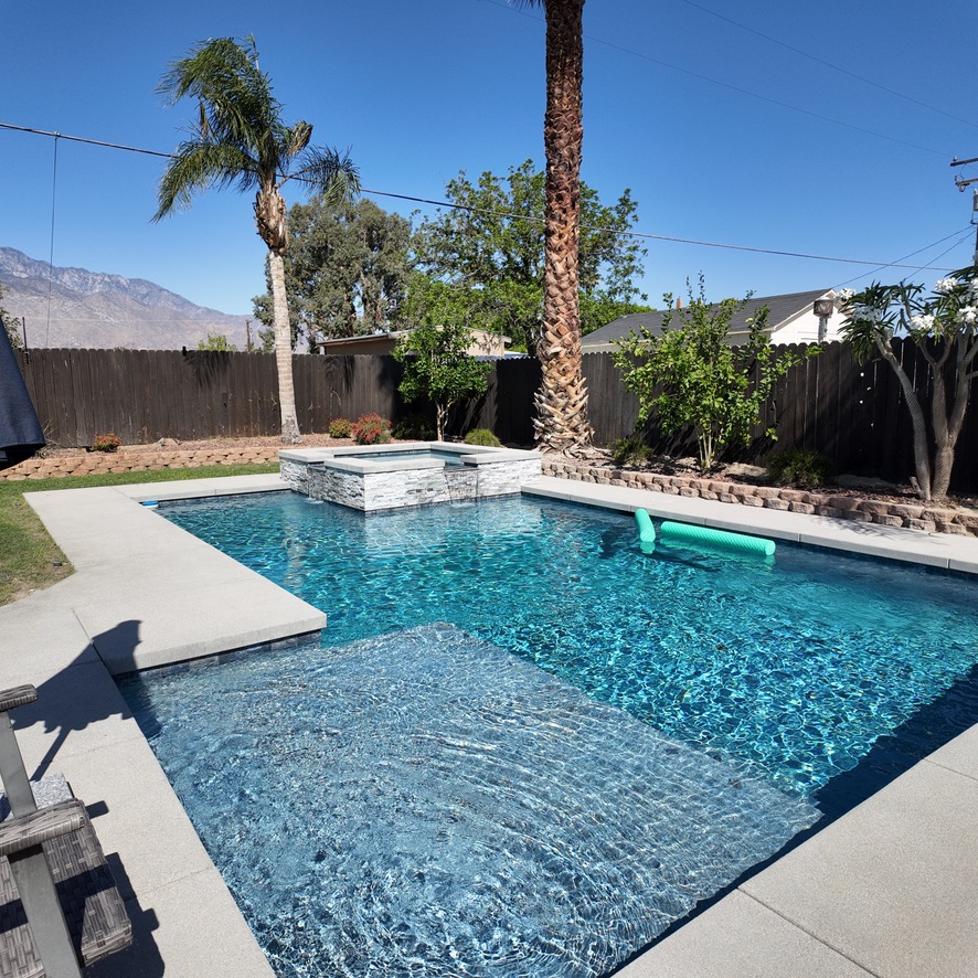 custom swimming pool with raised spa and rock exterior