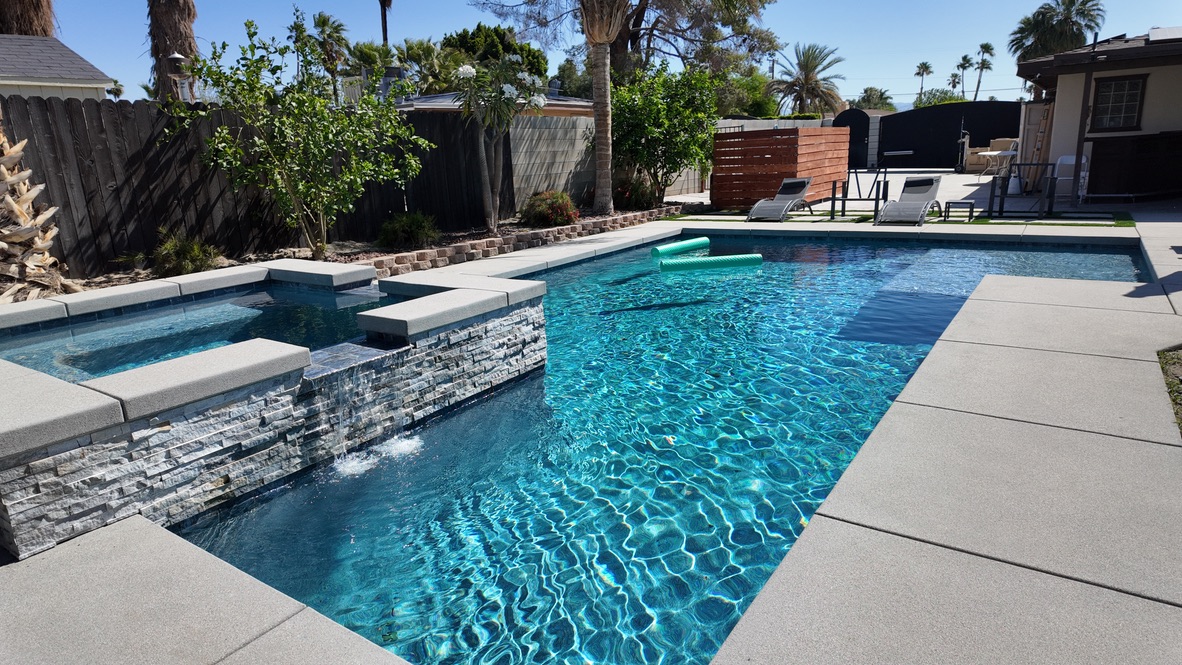 swimming pool with rock spa and blue interior finish